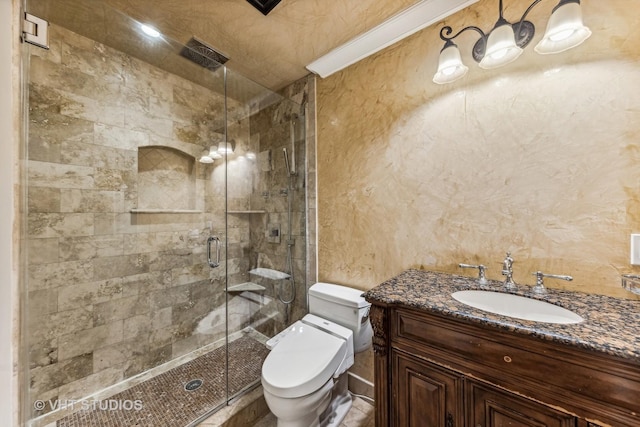 bathroom featuring vanity, a shower with shower door, and toilet