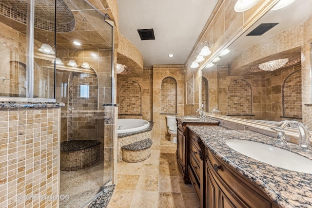 full bathroom with vanity, separate shower and tub, tile walls, and toilet