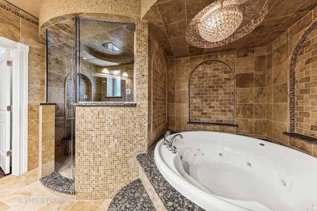 bathroom featuring tile patterned floors, plus walk in shower, and tile walls