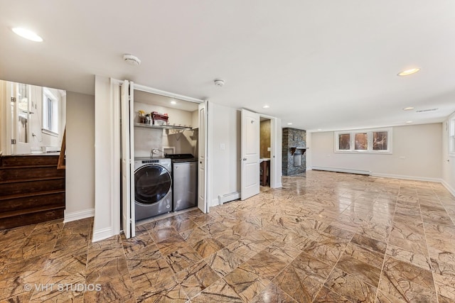 unfurnished living room featuring independent washer and dryer, a fireplace, and baseboard heating