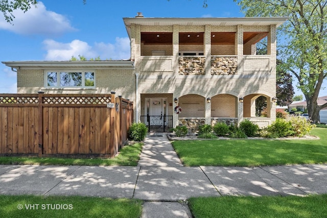 view of front of property with a balcony and a front lawn