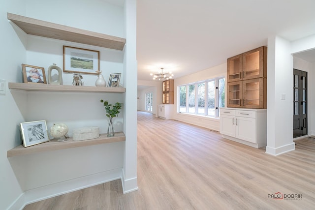 interior space with an inviting chandelier and light hardwood / wood-style floors