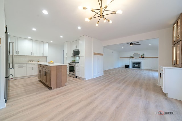 kitchen with a kitchen island, white cabinets, backsplash, stainless steel appliances, and light hardwood / wood-style flooring