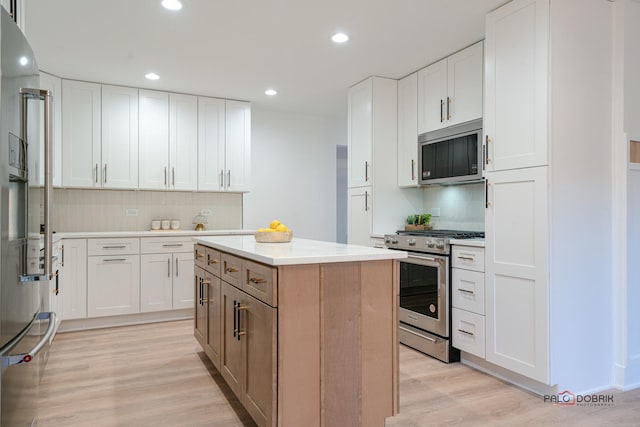 kitchen with white cabinetry, stainless steel appliances, and a kitchen island