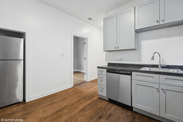 kitchen with sink, dark wood-type flooring, gray cabinets, and appliances with stainless steel finishes