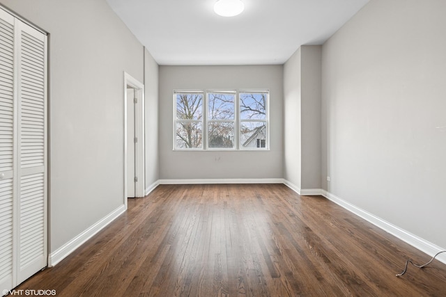 unfurnished bedroom with dark hardwood / wood-style flooring and a closet