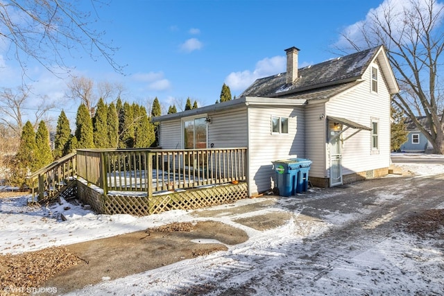 snow covered house featuring a wooden deck