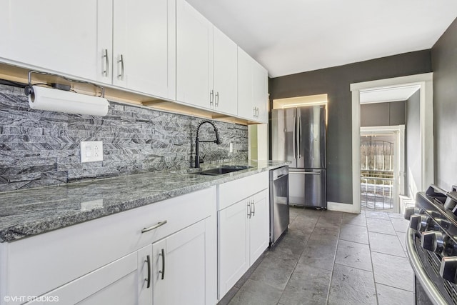 kitchen with light stone counters, backsplash, stainless steel appliances, and white cabinets