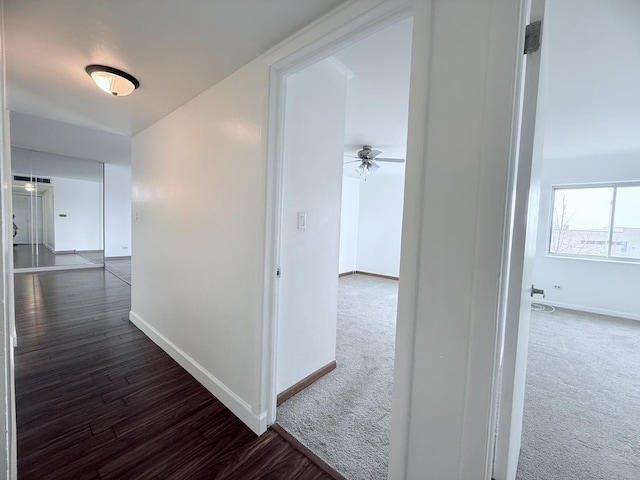 hall featuring dark colored carpet