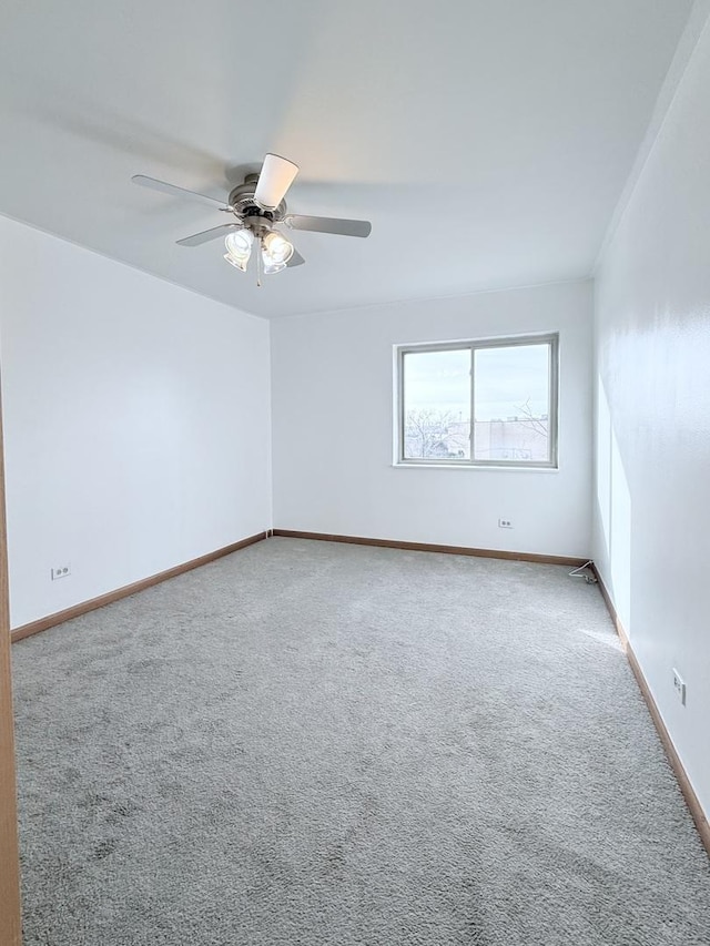 empty room featuring ceiling fan and carpet