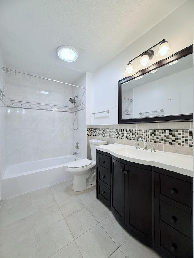 full bathroom featuring tiled shower / bath, tile walls, tile patterned flooring, vanity, and toilet