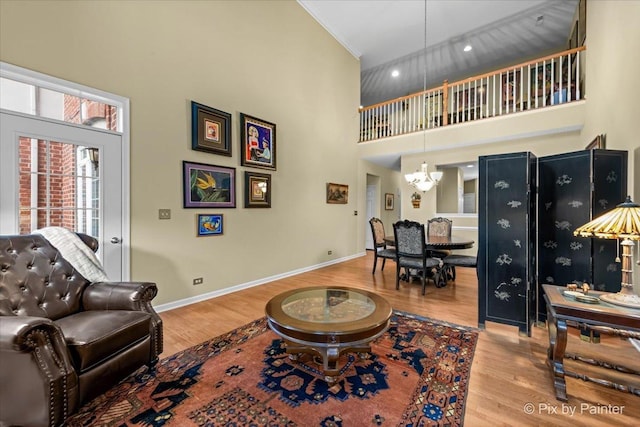 living room with a towering ceiling, hardwood / wood-style floors, and a notable chandelier