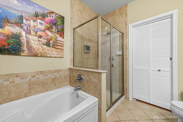 bathroom featuring tile patterned flooring, shower with separate bathtub, and toilet