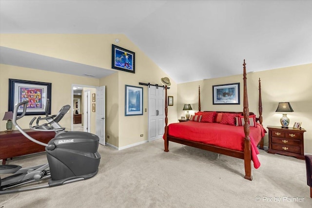 bedroom with lofted ceiling, a barn door, and light carpet