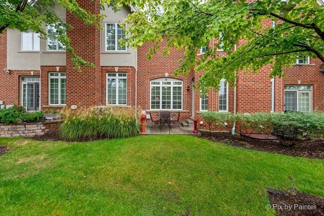 rear view of house featuring a patio area and a lawn