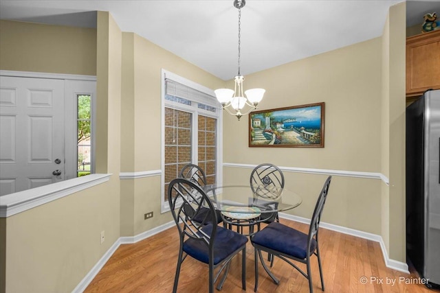 dining space featuring an inviting chandelier and light hardwood / wood-style flooring