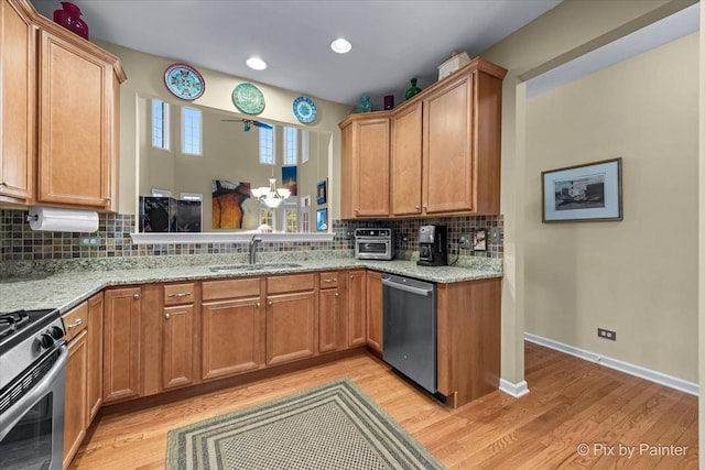 kitchen featuring tasteful backsplash, sink, light hardwood / wood-style flooring, and stainless steel appliances