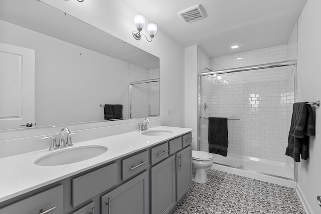 bathroom featuring an enclosed shower, vanity, tile patterned floors, and toilet