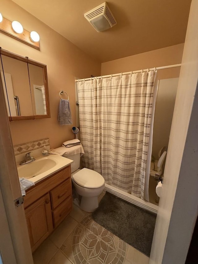 bathroom featuring a shower with curtain, vanity, tile patterned floors, and toilet