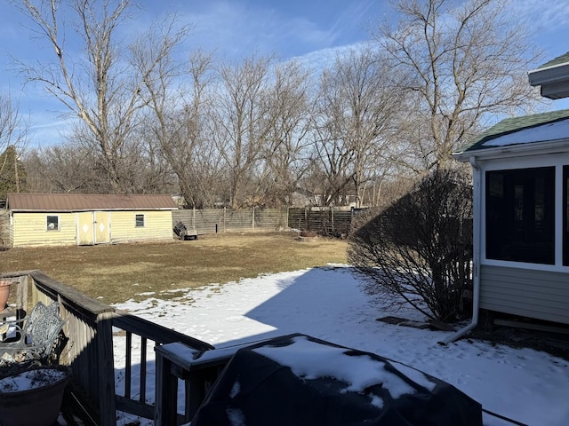 yard layered in snow featuring a shed