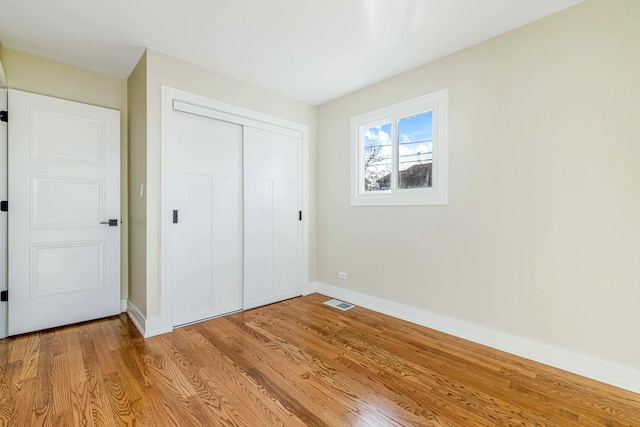 unfurnished bedroom featuring light hardwood / wood-style floors and a closet