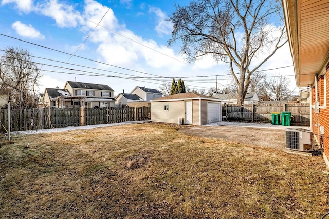 view of yard featuring a garage, an outdoor structure, and central AC unit