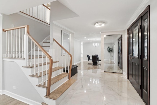 foyer entrance featuring crown molding and an inviting chandelier