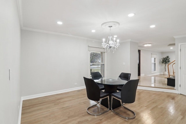 dining space featuring light hardwood / wood-style flooring, ornamental molding, and a chandelier