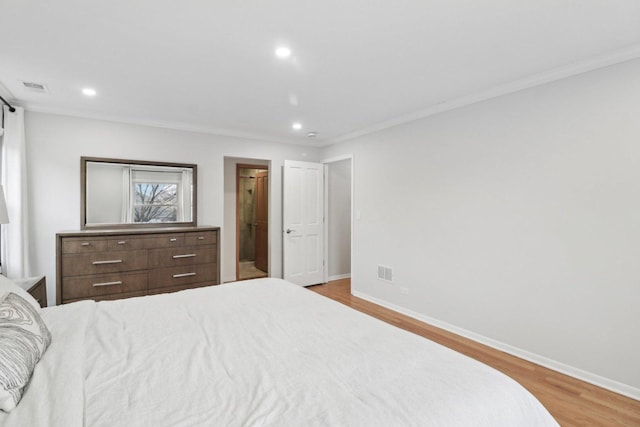 bedroom with ornamental molding, ensuite bathroom, and light hardwood / wood-style flooring