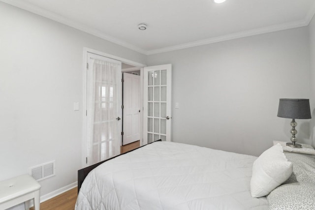 bedroom featuring crown molding and wood-type flooring