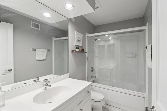 full bathroom featuring enclosed tub / shower combo, vanity, and toilet