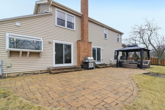 rear view of property featuring a gazebo, an outdoor hangout area, and a patio area