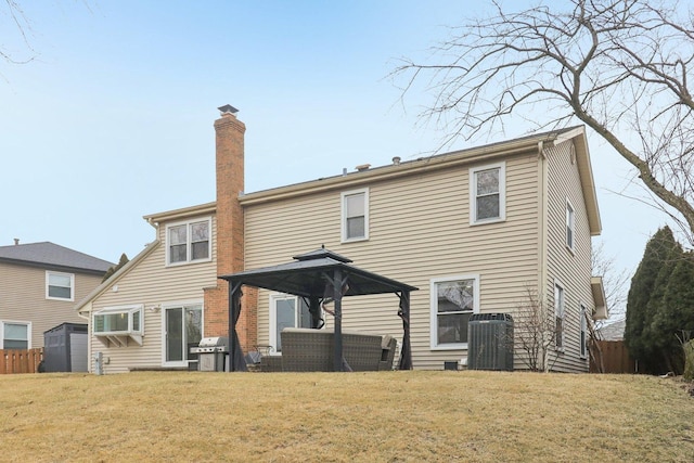 rear view of house with a gazebo, a wall mounted air conditioner, central AC, and a lawn