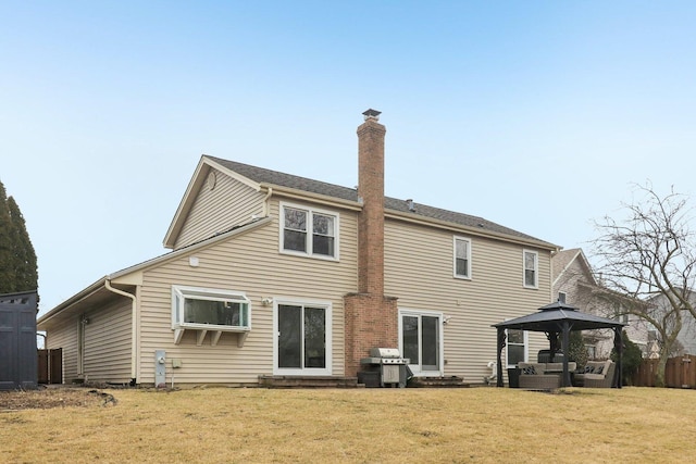 back of property with a gazebo and a lawn