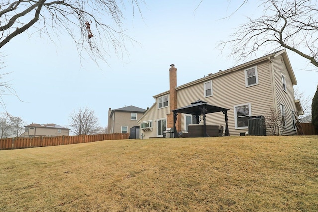 rear view of property with a gazebo and a lawn