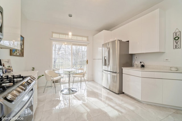 kitchen with white cabinetry, appliances with stainless steel finishes, and decorative light fixtures