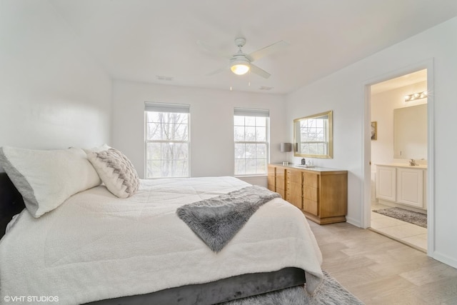 bedroom featuring connected bathroom, light hardwood / wood-style floors, and ceiling fan