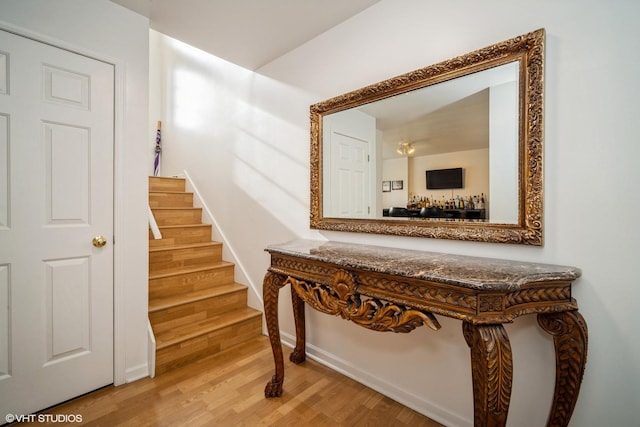 stairs with hardwood / wood-style floors and indoor bar