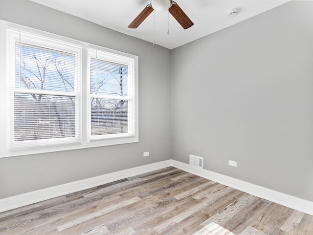 spare room with light wood-type flooring and ceiling fan