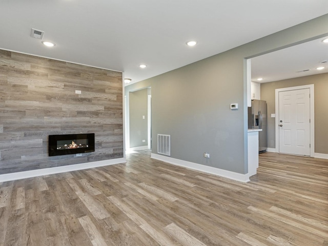 unfurnished living room with a fireplace and light hardwood / wood-style flooring