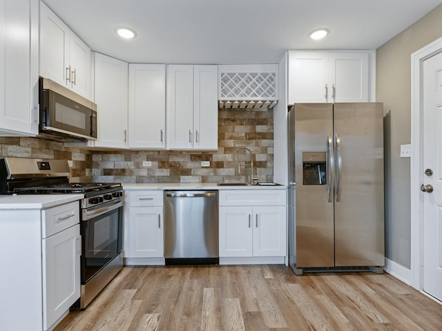 kitchen with stainless steel appliances, sink, and white cabinets