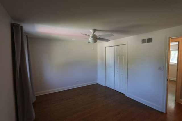 unfurnished bedroom featuring ceiling fan, dark hardwood / wood-style flooring, and a closet