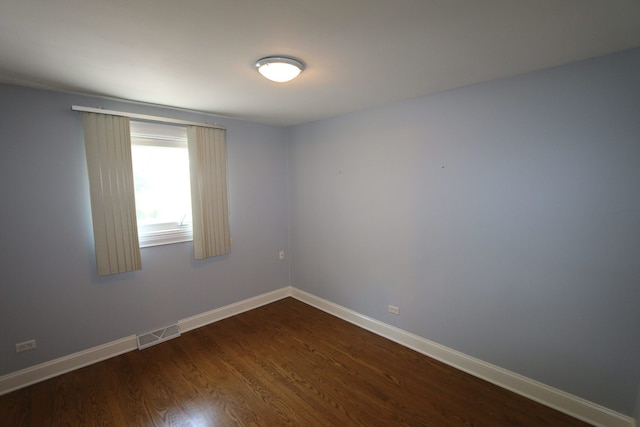 empty room with dark hardwood / wood-style flooring