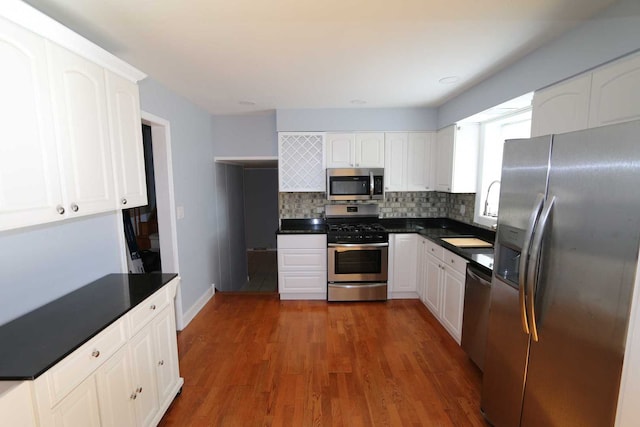 kitchen featuring white cabinetry, appliances with stainless steel finishes, backsplash, and dark hardwood / wood-style flooring