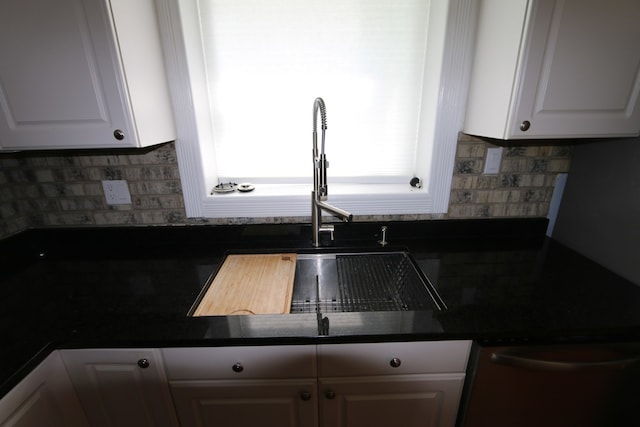 kitchen with white cabinetry, backsplash, stainless steel dishwasher, and sink