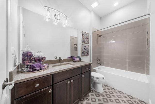 full bathroom with tiled shower / bath, vanity, and toilet