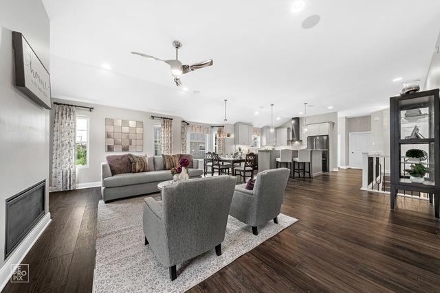 living room with dark wood-type flooring and ceiling fan