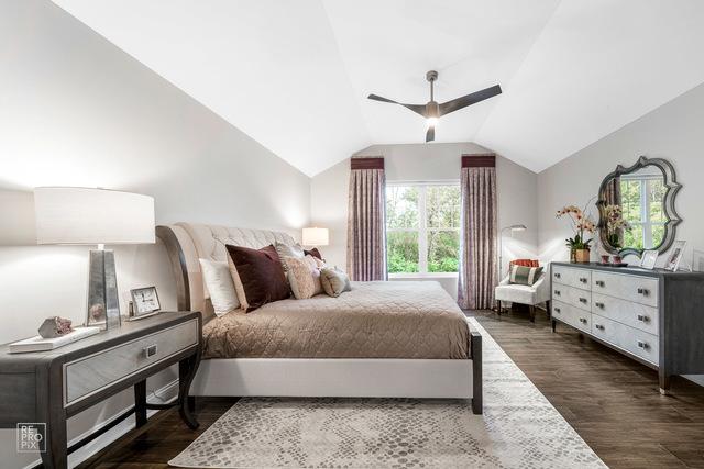 bedroom with dark wood-type flooring, ceiling fan, and vaulted ceiling