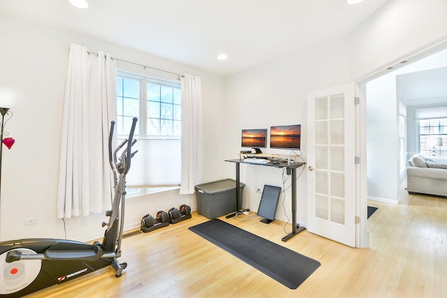 workout area featuring french doors and light hardwood / wood-style flooring