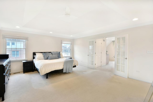 carpeted bedroom with crown molding, french doors, and a raised ceiling